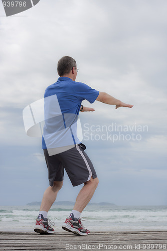 Image of Mature runner doing squats