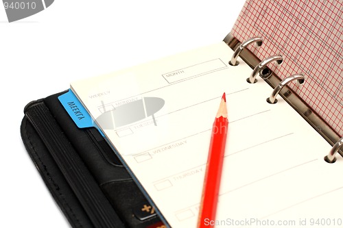 Image of open black organizer and red pencil