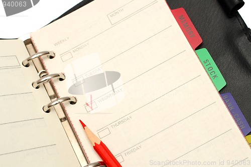 Image of open organizer and red pencil