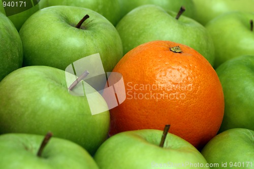 Image of different concepts - orange between apples