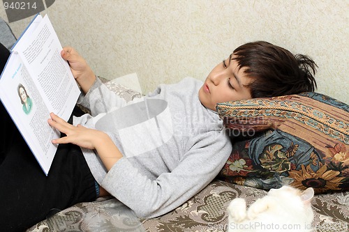 Image of boy on bed with cat, reading bok