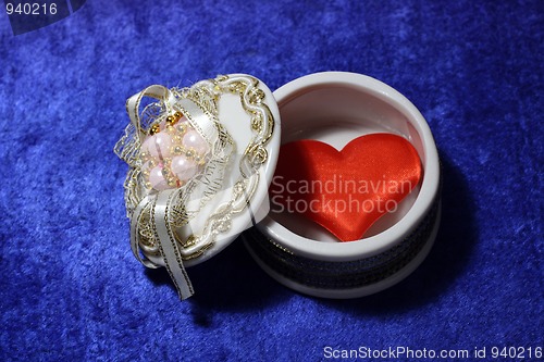 Image of red heart in open box on blue velvet