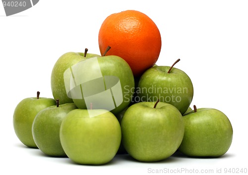 Image of domination concepts - orange on pyramyd of apples