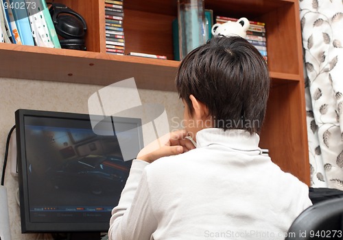 Image of boy at table, looking to monitor