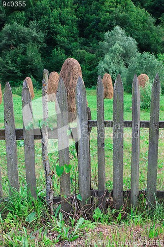 Image of Haystacks behind a wooden fence