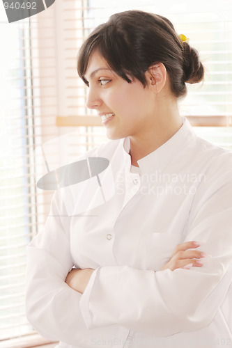 Image of Smiling brunette in smock looking to window