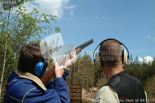 Image of Man shooting clay pigeons being instructed