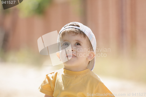 Image of Little boy in yellow looking up
