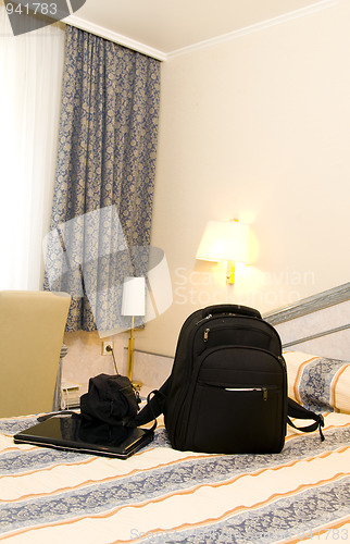 Image of hotel room with backpack and laptop on bed