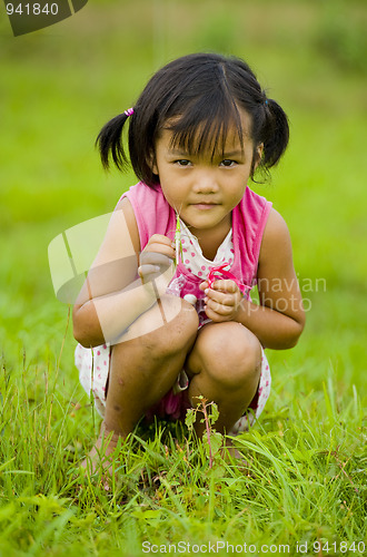 Image of cute asian girl holding a grasshopper