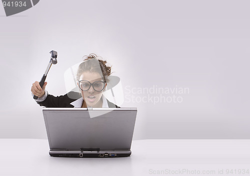 Image of Angry brunette businesswoman with hammer