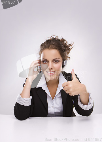Image of Pretty young business woman with thumb up