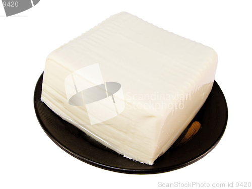 Image of  Tofu on a black wooden plate.This is raw tofu which can be cooked in different ways