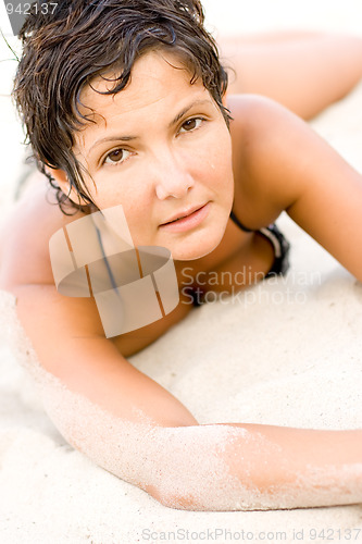 Image of brunet woman lying on a sand