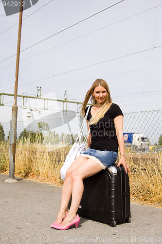 Image of girl sitting on a suitcase
