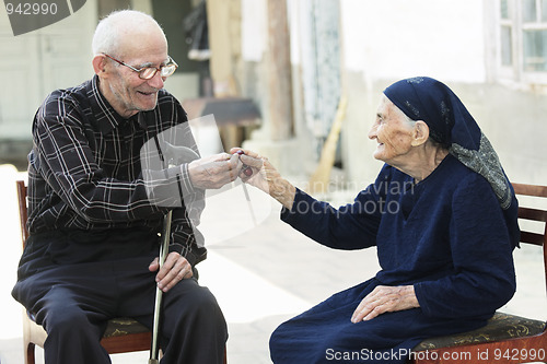 Image of Senior man giving cherry to woman