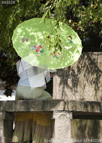 Image of Tongli: lonely lady under umbrella caught in romantic thought.