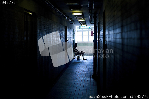 Image of man sitting in the corridor in a building