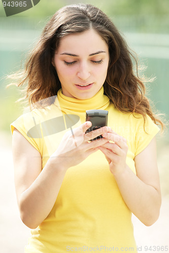 Image of Young woman reading message on cellphone