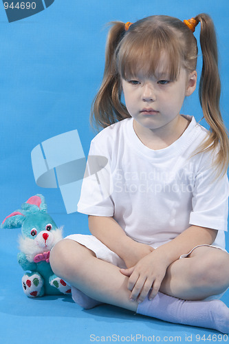 Image of Small cute girl is posing on blue background