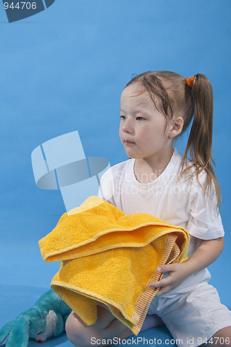 Image of Small girl is keeping yellow towel isolated