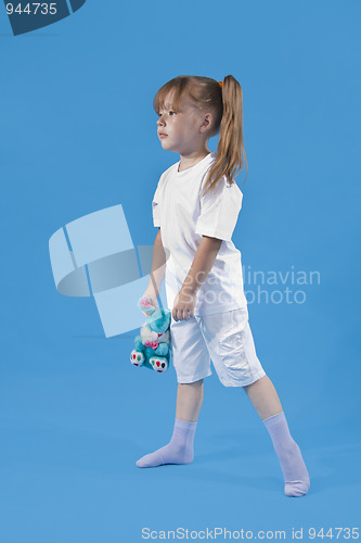 Image of Small cute girl is posing on blue background