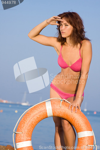 Image of A young girl on the beach with a Life Ring