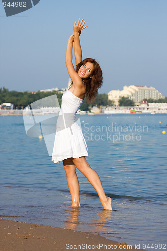 Image of Young beautiful girl in a white dress on the beach