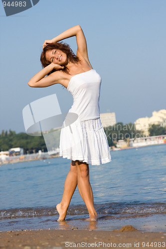 Image of Young beautiful girl in a white dress on the beach