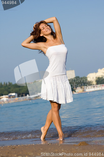 Image of Young beautiful girl in a white dress on the beach