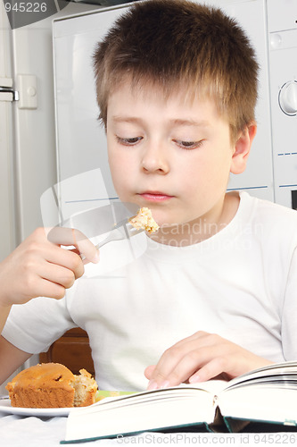 Image of Kid at breakfast with book