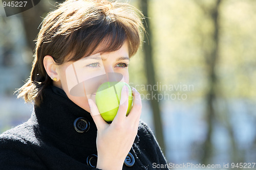 Image of Cute woman in park with apple