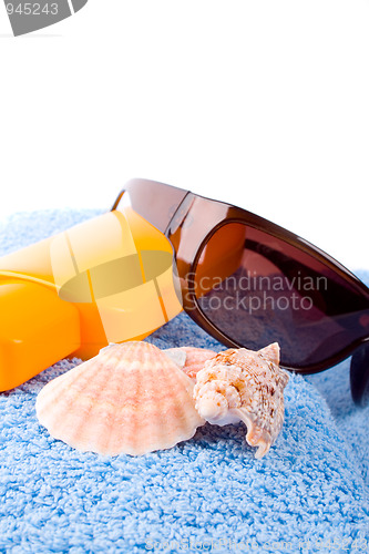 Image of towel, shells, sunglasses and lotion