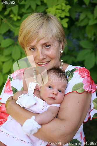 Image of Grandmother outdoors on patio with baby