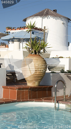 Image of greek island swimming pool with wind mill santorini