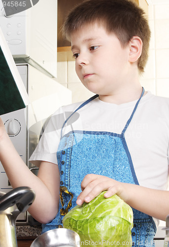 Image of Boy with cabbage looking to cookbook