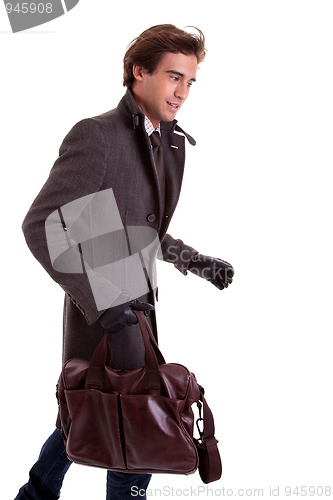 Image of Portrait of a young man with a handbag, hasty, in autumn/winter clothes