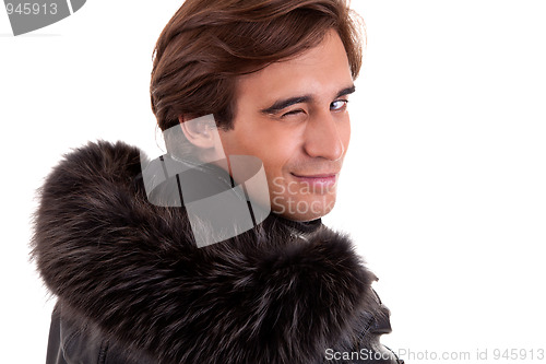 Image of Portrait of a young man winking from back, in autumn/winter clothes