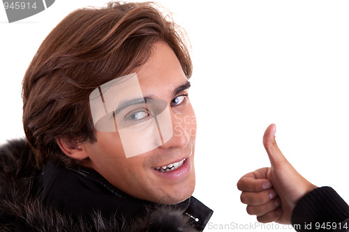 Image of Portrait from back of a young man with thumb up, in autumn/winter clothes