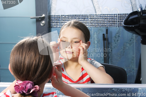Image of Girl narrowing eyes at mirror