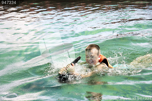 Image of Boy swimming with dolphin