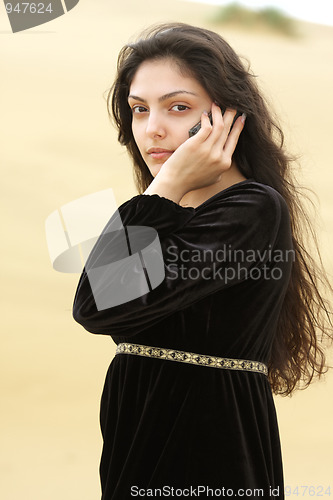 Image of Young woman in desert calling by cellphone
