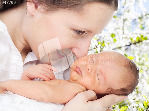 Image of Mother with newborn in cherry tree garden