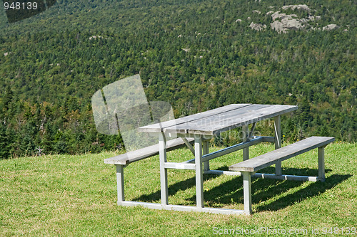 Image of Picnic table with view over mountain forest