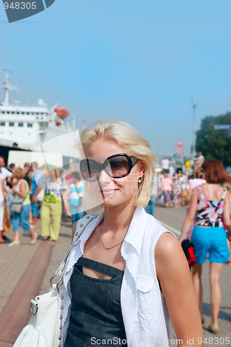 Image of Young woman in sunglasses on  sea port 