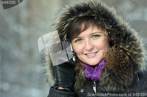 Image of Smiling woman calling cellphone in frosty day