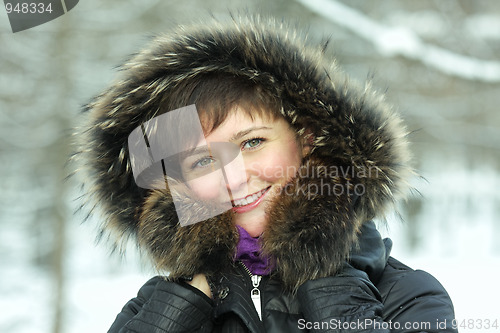 Image of Smiling woman in frosty day hands at hood