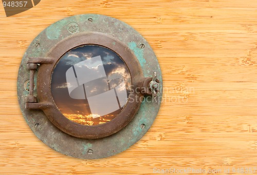Image of Antique Porthole with View of Sunset on Bamboo Wall