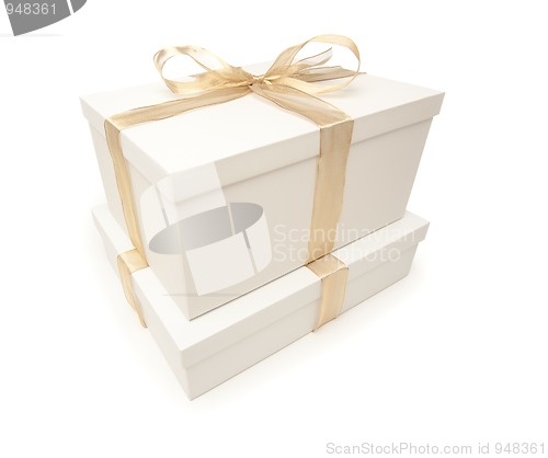 Image of Stacked White Gift Boxes with Gold Ribbon Isolated