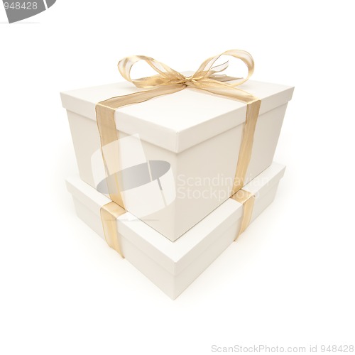 Image of Stacked White Gift Boxes with Gold Ribbon Isolated